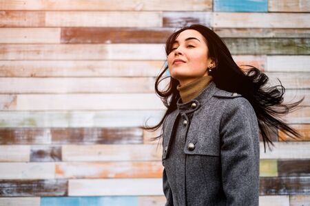 Young brunette woman outdoor with blowing up hairの写真素材