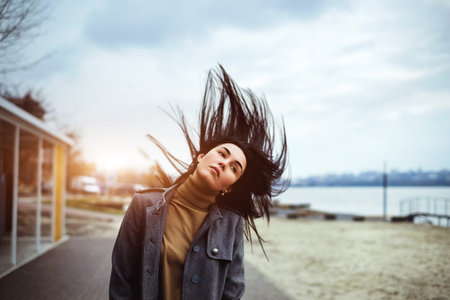 Young brunette woman outdoor with blowing up hair