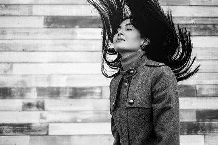 Young brunette girl outdoor with blowing up hairの写真素材