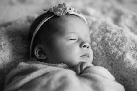 cute newborn baby girl in the bed, black and whiteの写真素材