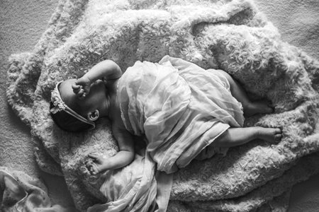 cute newborn baby girl in the bed, black and white
