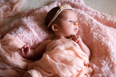 cute newborn baby girl in the bedの写真素材