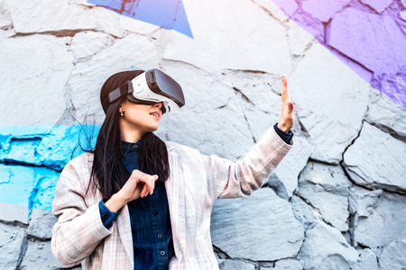 Brunette girl outdoor enjoying virtual reality glassesの写真素材