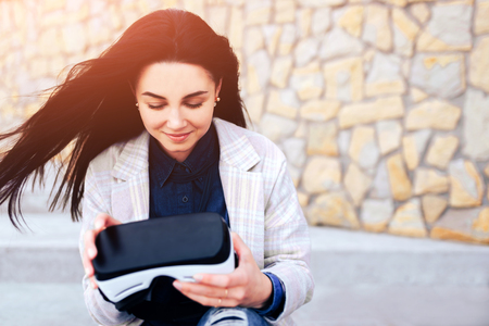 Brunette girl outdoor enjoying virtual reality glassesの写真素材