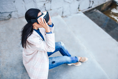 Brunette girl outdoor enjoying virtual reality glassesの写真素材