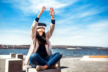 Brunette girl outdoor enjoying virtual reality glassesの写真素材