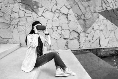 Brunette girl outdoor in VR glasses, black and whiteの写真素材