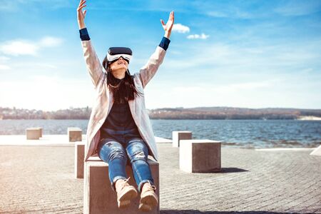 Brunette girl outdoor enjoying virtual reality glassesの写真素材