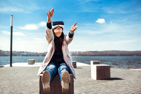 Brunette girl outdoor enjoying virtual reality glassesの写真素材