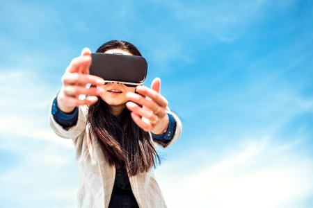 Brunette girl outdoor enjoying virtual reality glassesの写真素材