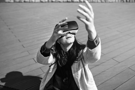 Brunette girl outdoor in VR glasses, black and whiteの写真素材