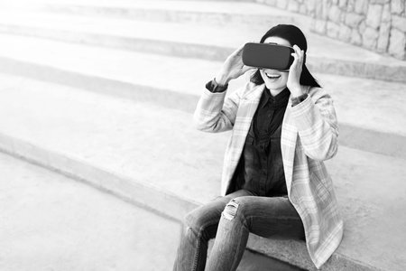 Brunette girl outdoor in VR glasses, black and white