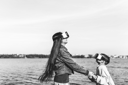 Sister with little brother playing in VR glasses, black and whiteの写真素材