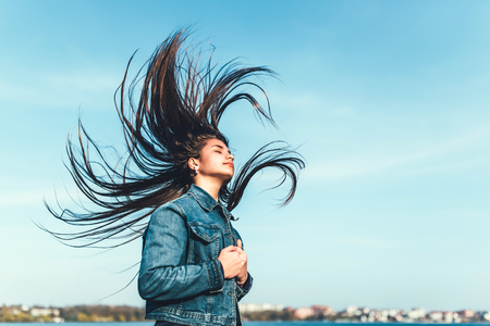 Young girl with long streaming hair outdoorの写真素材