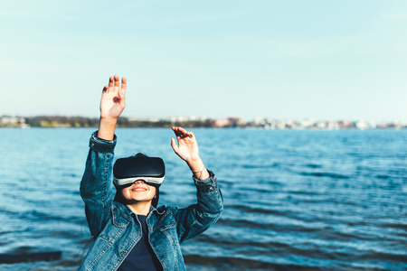 Young girl in virtual reality glasses outdoorの写真素材