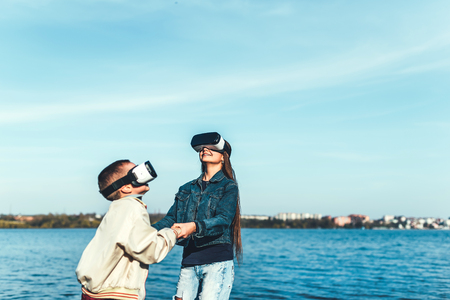 Sister with little brother playing in VR glassesの写真素材