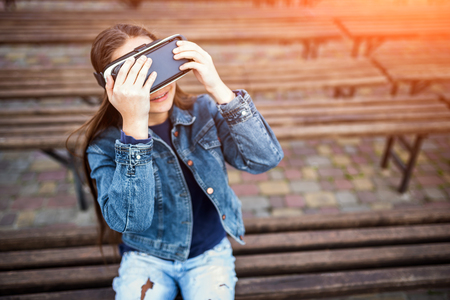 Young girl in virtual reality glasses outdoorの写真素材
