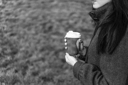 Long hair brunette girl with cup of coffee outdoor, black and whiteの写真素材