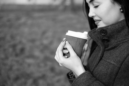 Long hair brunette girl with cup of coffee outdoor, black and whiteの写真素材