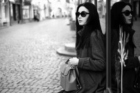 Woman on the street with backpack in hands, black and whiteの写真素材