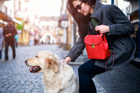 Brunette woman with dog outdoor on the streetの写真素材