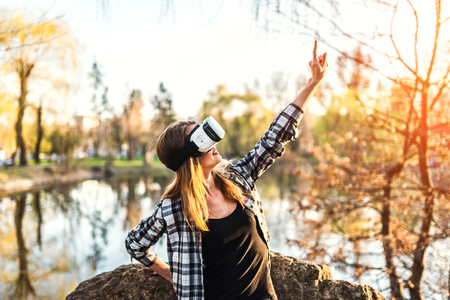 Pretty girl enjoy virtual reality glasses outdoorの写真素材