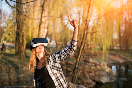 Pretty girl enjoy virtual reality glasses outdoorの写真素材