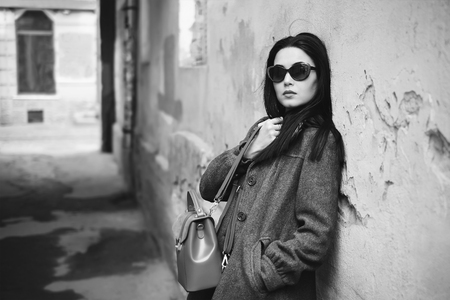 Long hair brunette girl near old wall, black and whiteの写真素材