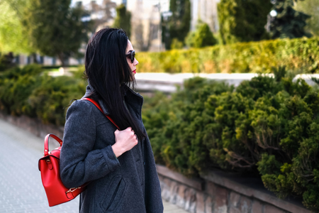 Woman outdoor on the street with red backpackの写真素材