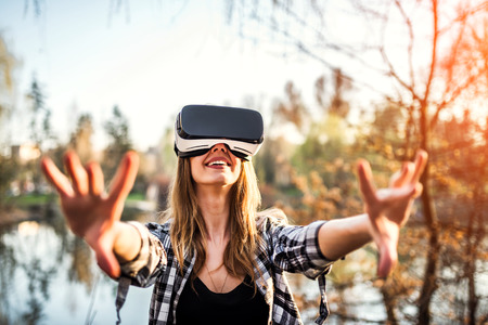 Pretty girl enjoy virtual reality glasses outdoorの写真素材