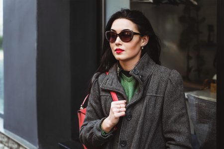 Young brunette girl walking on the street with red backpackの写真素材