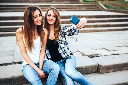 Two young girls making selfie in the parkの写真素材