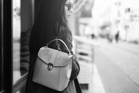 Young brunette girl walking on the street with red backpack, black and whiteの写真素材