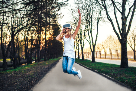 Pretty girl enjoy virtual reality glasses outdoorの写真素材