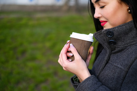 Long hair brunette girl with cup of coffee outdoor