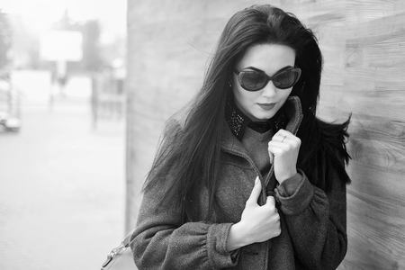 Long hair brunette girl near wooden wall with backpack, black and whiteの写真素材