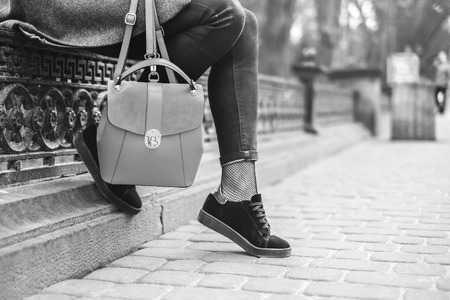 Woman sitting on the street with backpack, black and whiteの写真素材