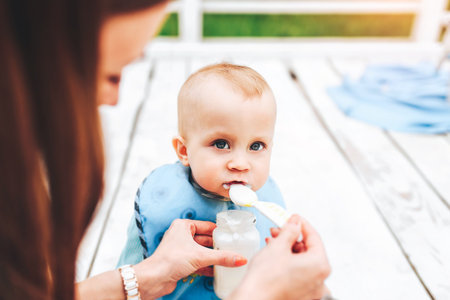 Young happy mother with her little son playing outdoor