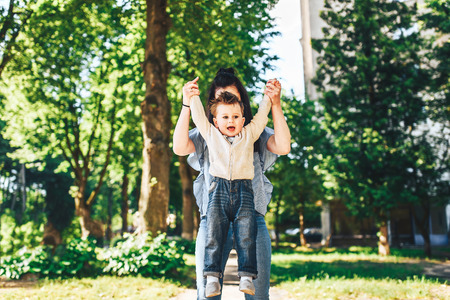 Young mother with her little son outdoor in the parkの写真素材