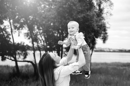 Young happy mother with her little son playing outdoor, black and whiteの写真素材