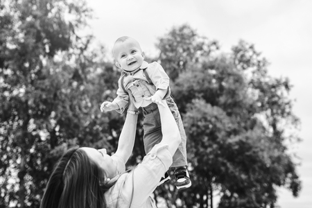 Young happy mother with her little son playing outdoor, black and whiteの写真素材