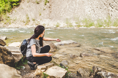 Tourist girl enjoy nature near mountain riverの写真素材