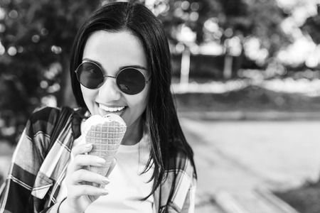 Pretty brunette girl enjoy ice cream on the street, black and whiteの写真素材