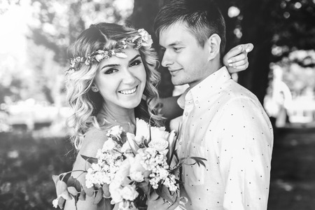 Beautiful young wedding couple outdoor in the park, black and whiteの写真素材