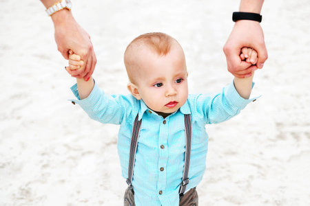 Happy young parents with little son playing outdoor in the park,