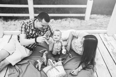 Young happy parents playing with little son outdoor in the park, black and whiteの写真素材