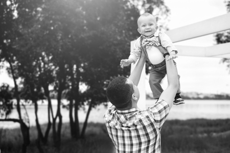 Young father with his little son have fun outdoor in the park, black and whiteの写真素材