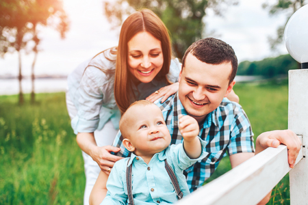Young happy parents playing with little son outdoor in the parkの写真素材