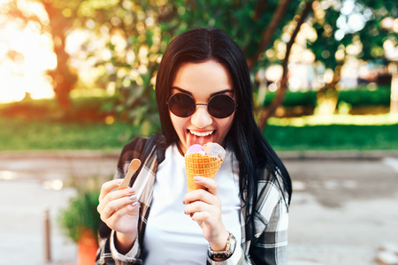 Pretty brunette girl enjoy ice cream on the streetの写真素材