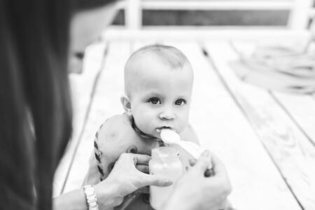 Young happy mother with her little son playing outdoor, black and whiteの写真素材